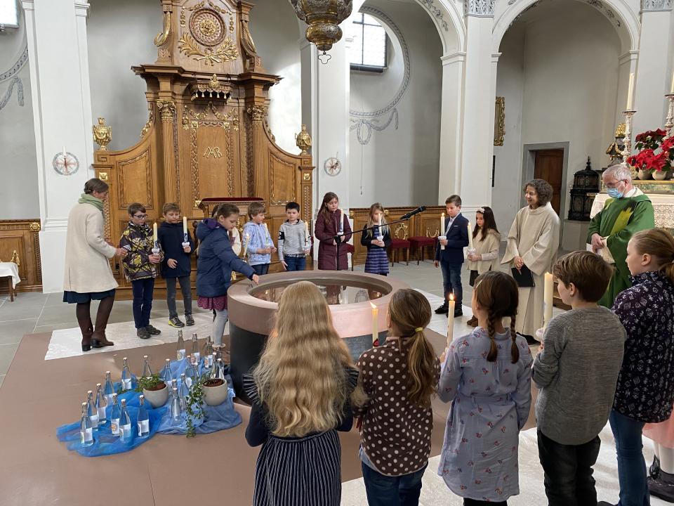 Kreuzzeichen mit dem Weihwasser aus dem Taufbrunnen