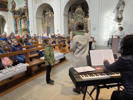 Die Taufkerze wird an der Osterkerze entzündet.